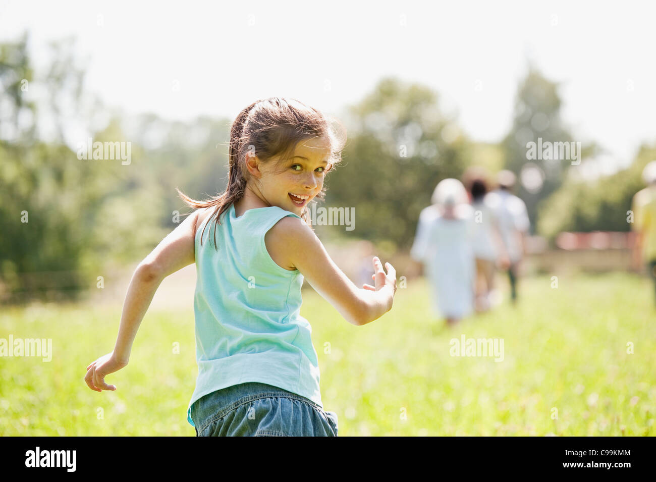 Germany, Bavaria, Girl running with family in background Stock Photo ...