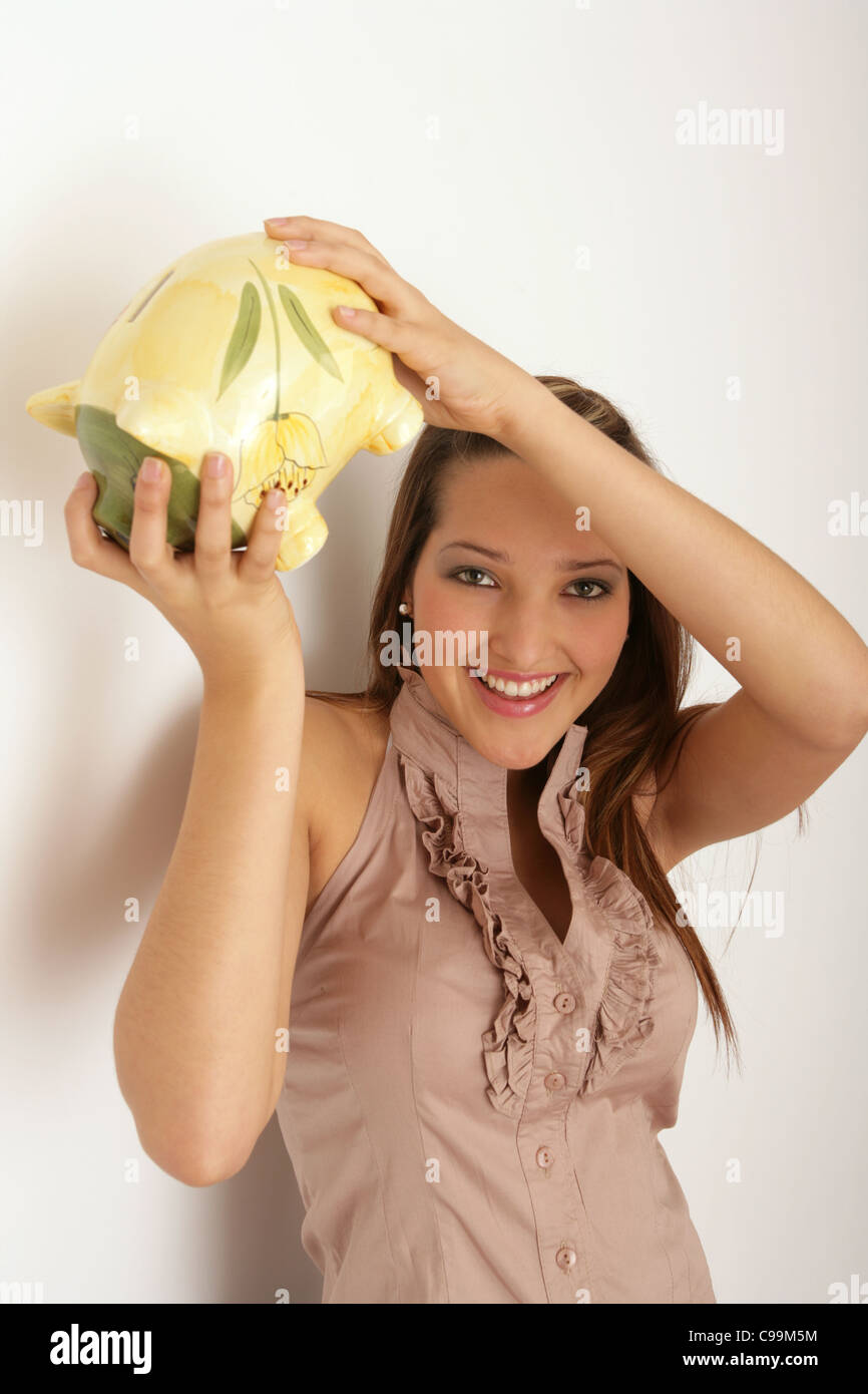 Pretty teenage girl holding a piggy bank above her head Stock Photo - Alamy