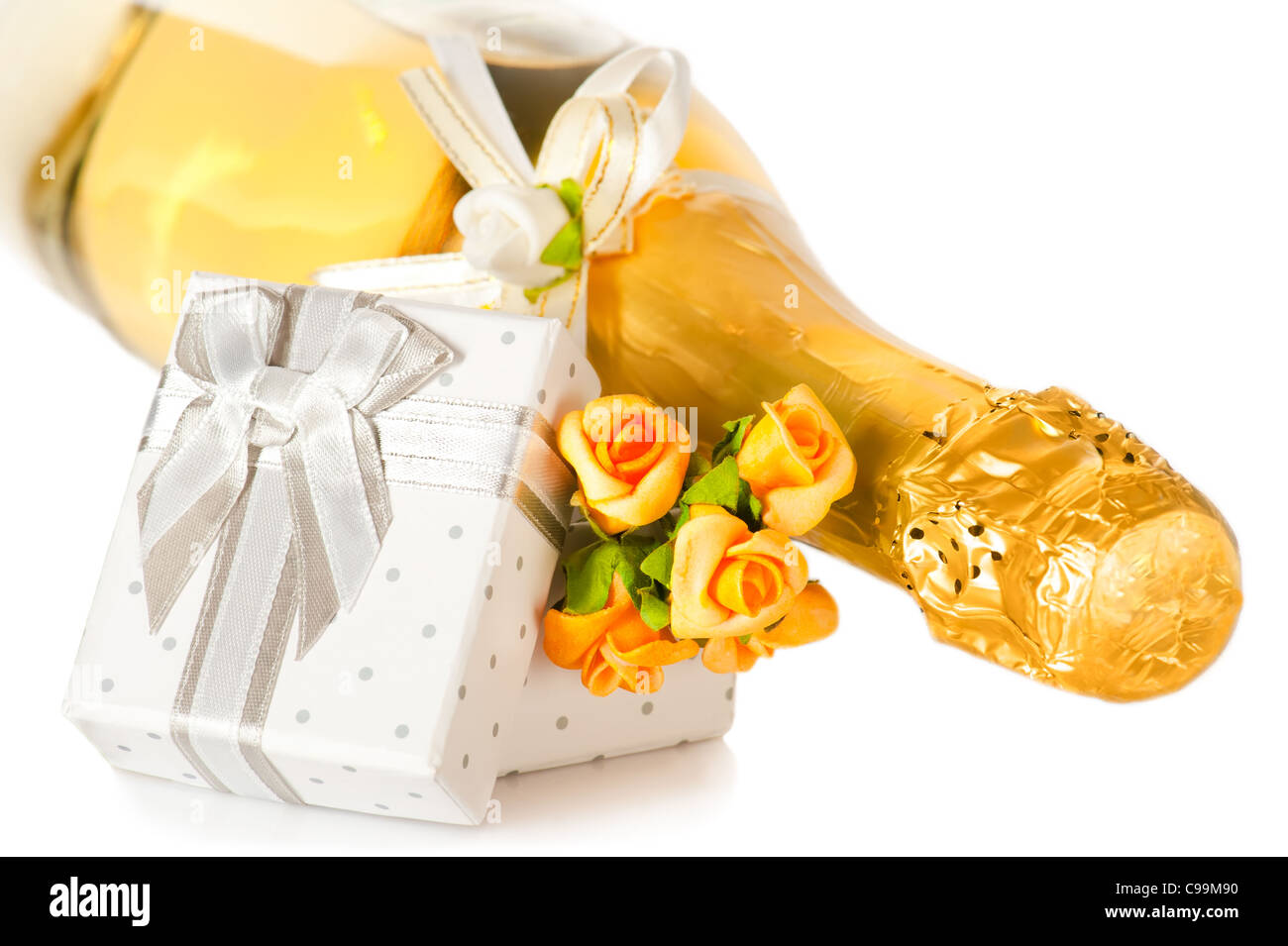 Champagne bottle, present box with bow and flower boutonniere on white background Stock Photo