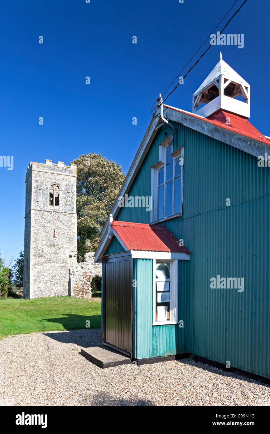 Ruined stone church of St Mary, Burgh Parva, beside its corrugated iron replacement, Melton Constable, Norfolk Stock Photo