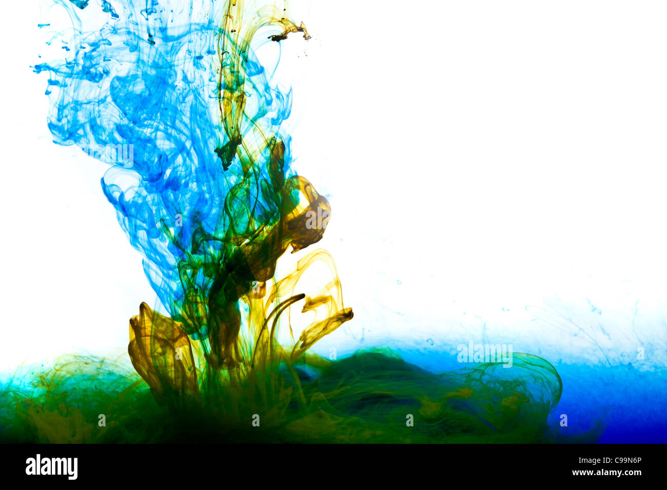 Side view of coloured inks mixing together in a tank of water Stock Photo