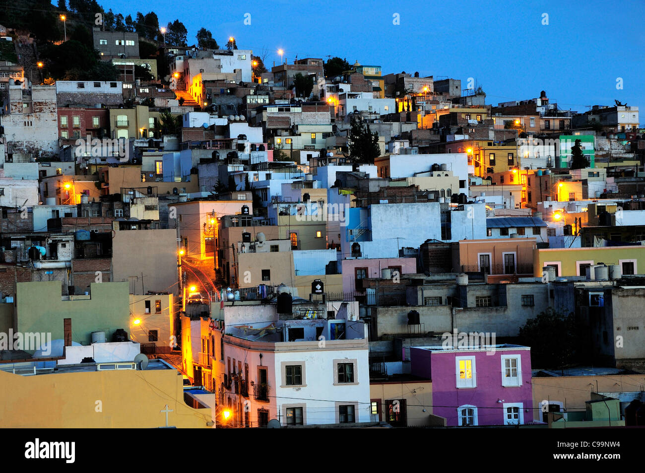 Mexico, Bajio, Zacatecas, Colourful housing across hillside at night