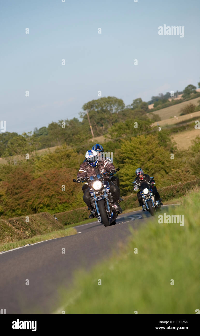 Motorcyclists riding along a rural road in England. Stock Photo