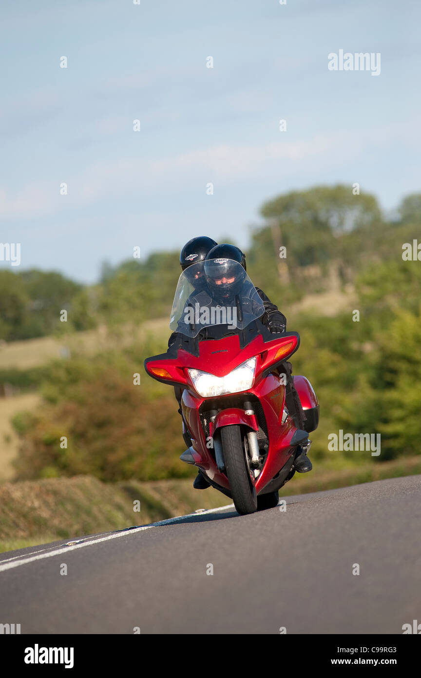 Motorcyclist riding along a rural road in England. Stock Photo