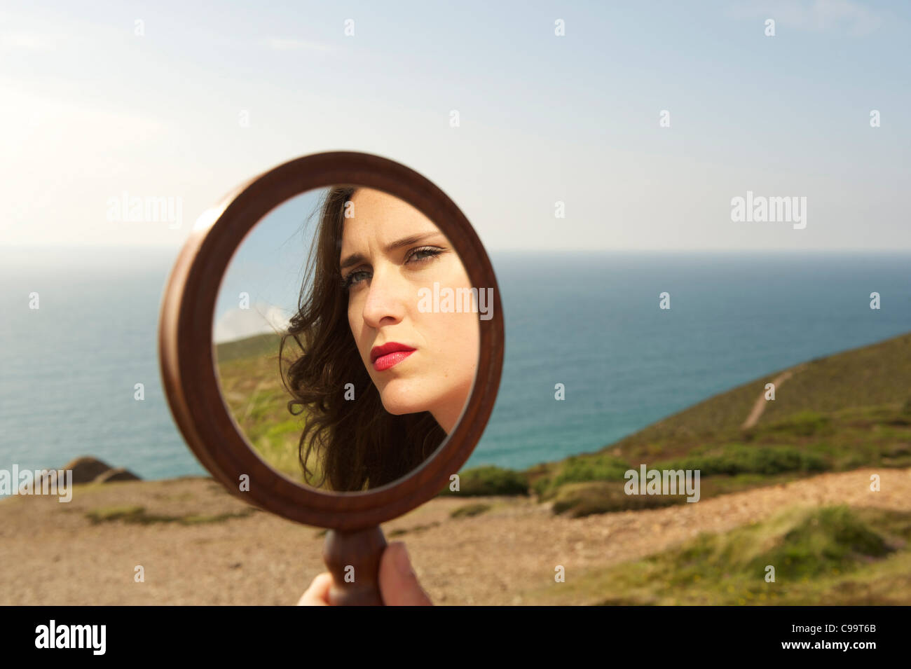 Beautiful young lady looking in a mirror Stock Photo