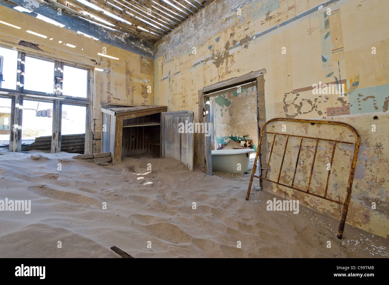 Room filled with sand in an abandoned house in Kolmanskop a former diamond mine in Namibia Stock Photo