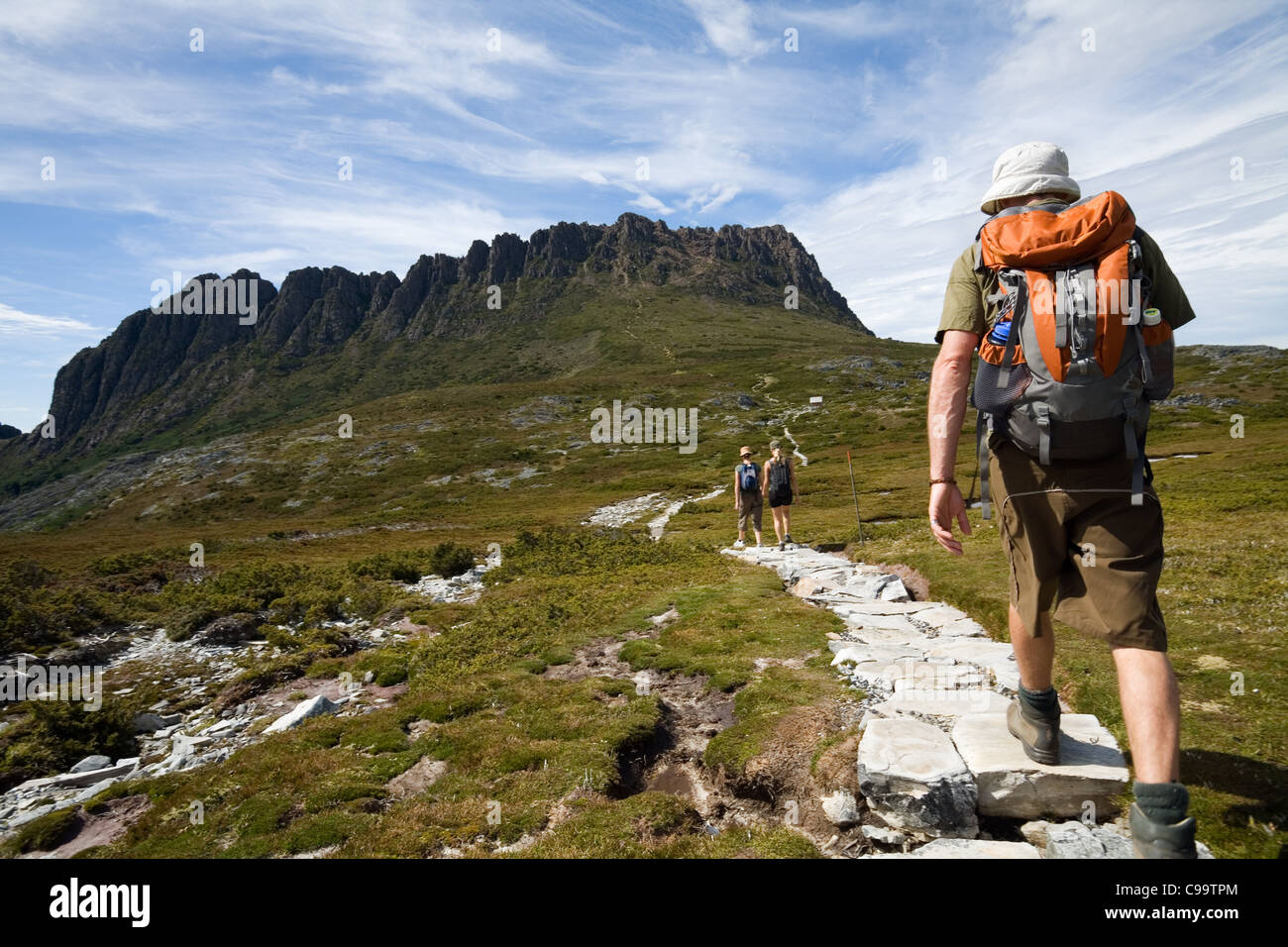 Hiker on the Overland Track with Cradle Mountain in background. Cradle