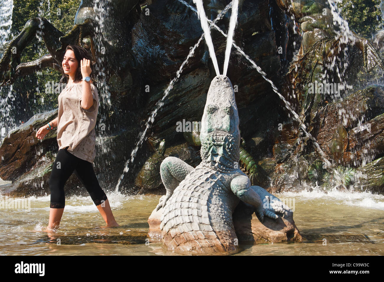 Young girl cooling down in Neptune fountain at Alexanderplatz,. Berlin, Germany. Stock Photo