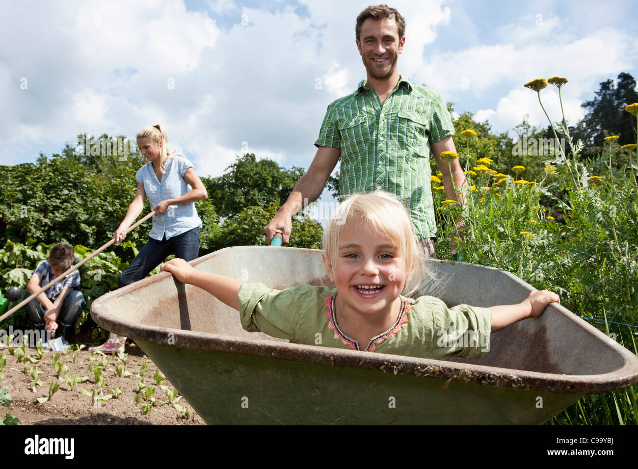 Germany, Bavaria, Altenthann, Family gardening together in garden Stock Photo