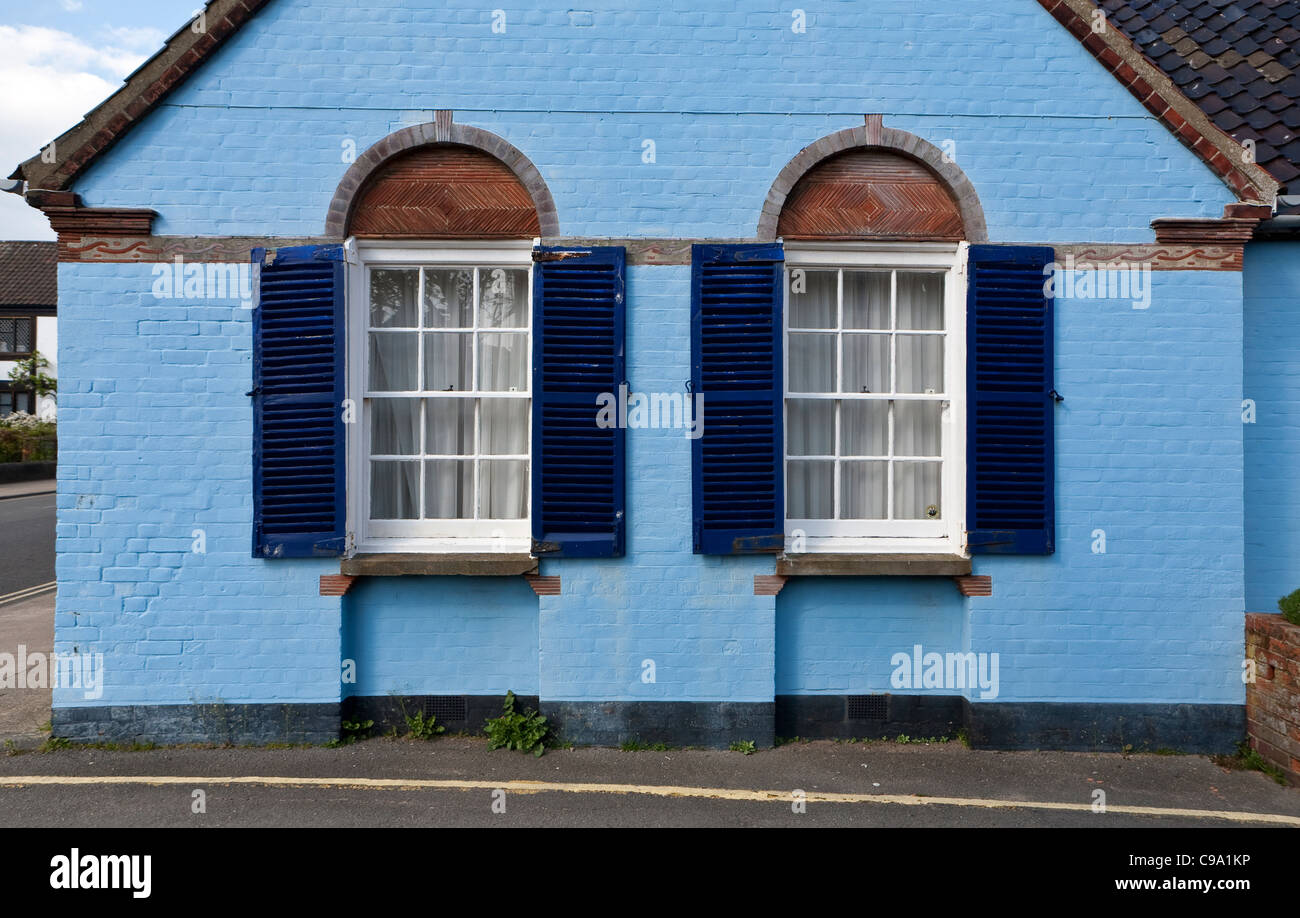 Blue-painted house with twin arched and shuttered sash windows seen in Aldeburgh, Suffolk. Stock Photo