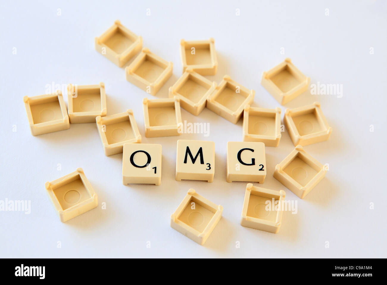 "OMG" spelled out in Scrabble letter tiles squares, sland txt texting chat speak, studio photograph Stock Photo
