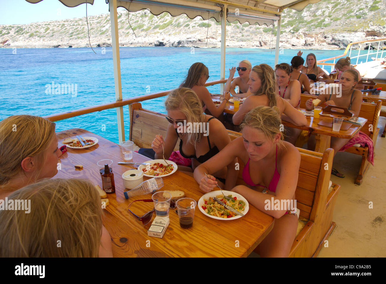Attractive beautiful group Dutch girls eating pasta on board of tourist yacht vacation Mallorca Majorca Balearic Spain Stock Photo