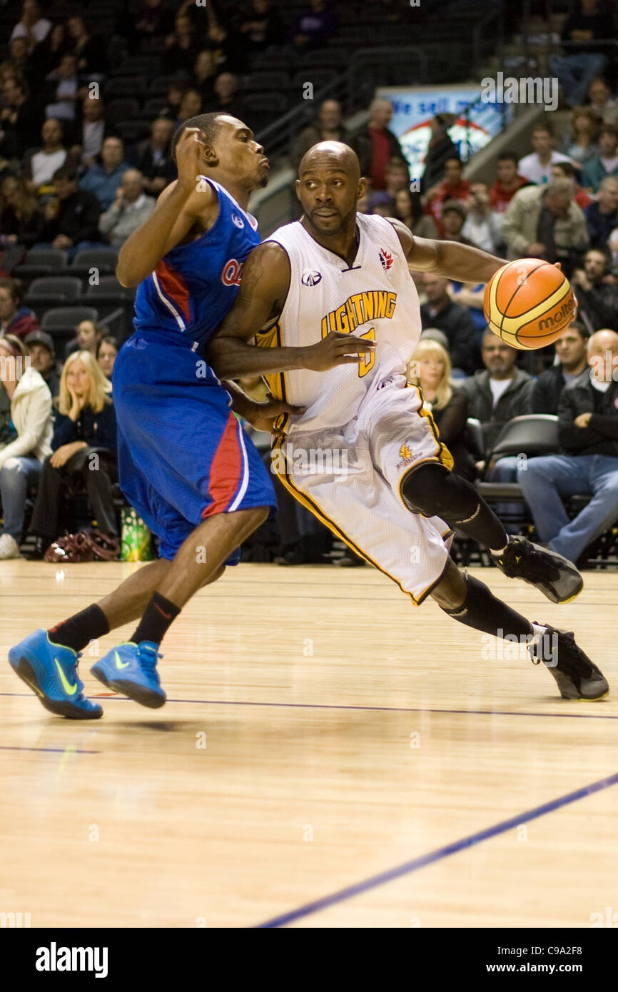 London Ontario, Canada - November 17, 2011. DeAnthony Bowden of the London Lightning carries the ball around Tommy Mitchell of the Quebec Kebs during a National Basketball League of Canada game between the London Lightning and Quebec Kebs. London won the game 85-79. Stock Photo