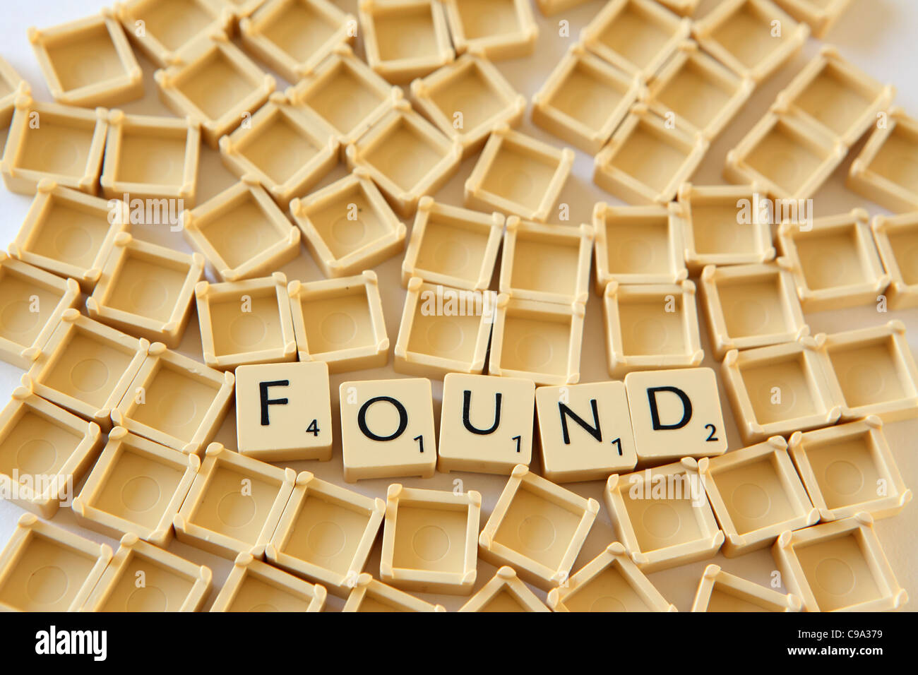 Scrabble tiles / squares spelledout "FOUND" , white background studio photograph Stock Photo