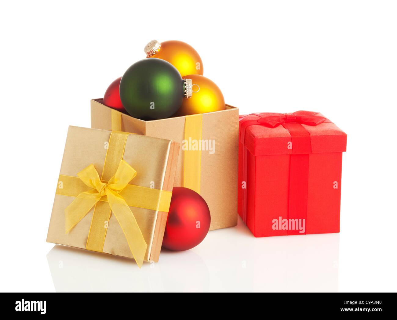 red and golden christmas gift boxes filled with baubles on white ...
