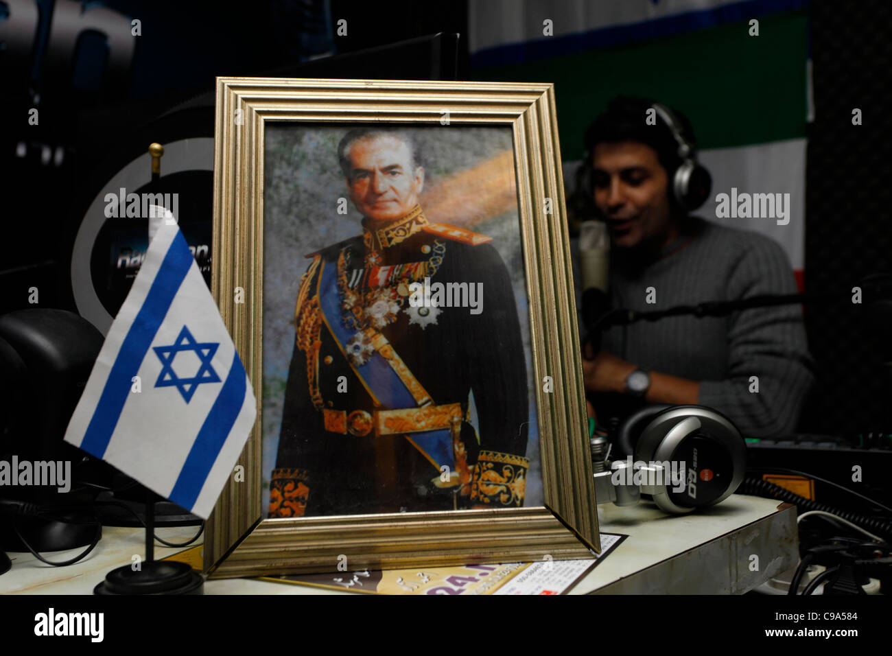 A portrait of Mohammad Reza Shah of Iran is seen with Rani Amrani an Israeli  Persian Jew broadcaster on air at Radioran an Iranian Radio station from  Israel in the town of