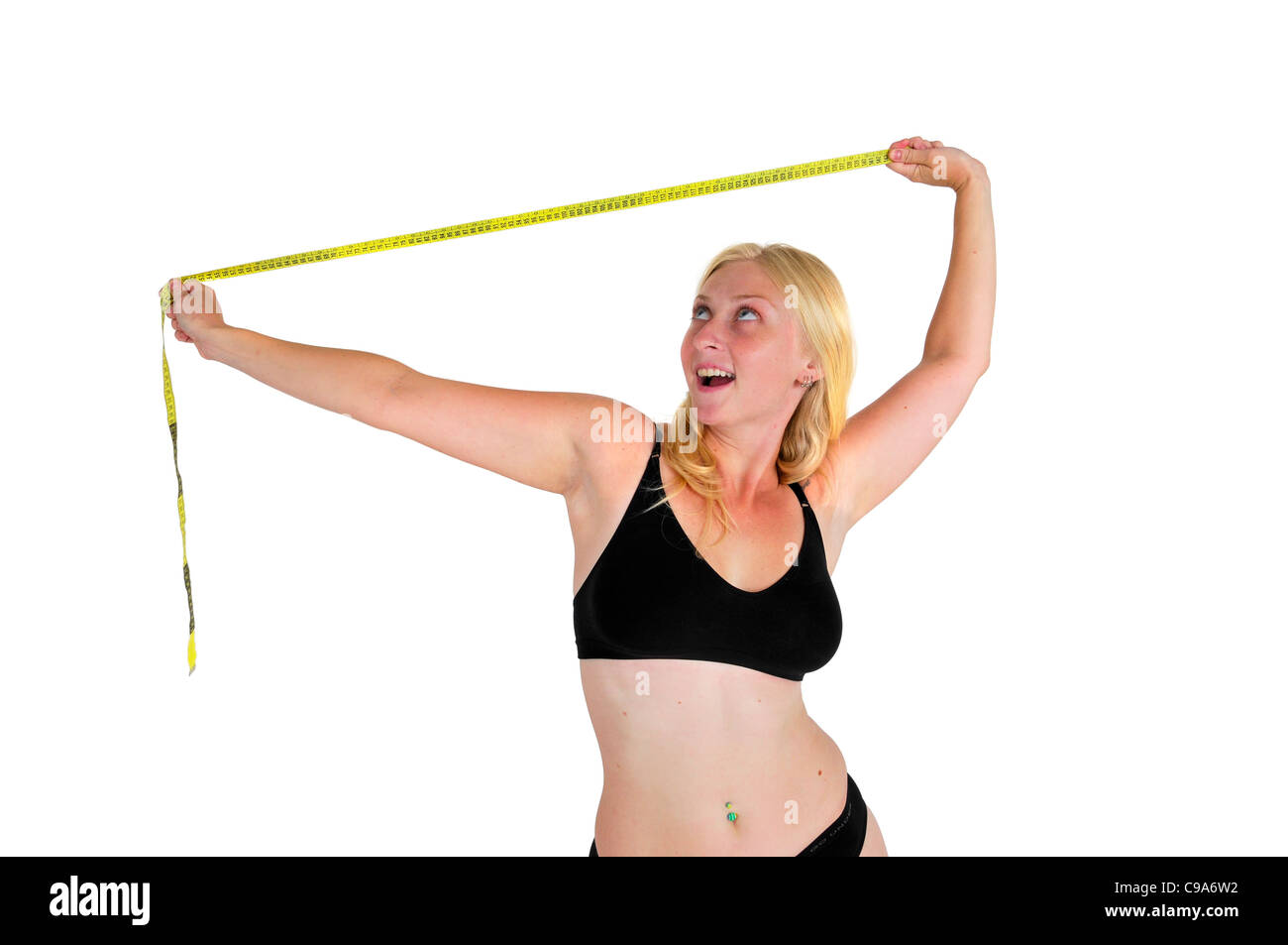 Young woman laughs at a tape measure. She has overcome compulsive body analysis caused by body image disorder Stock Photo