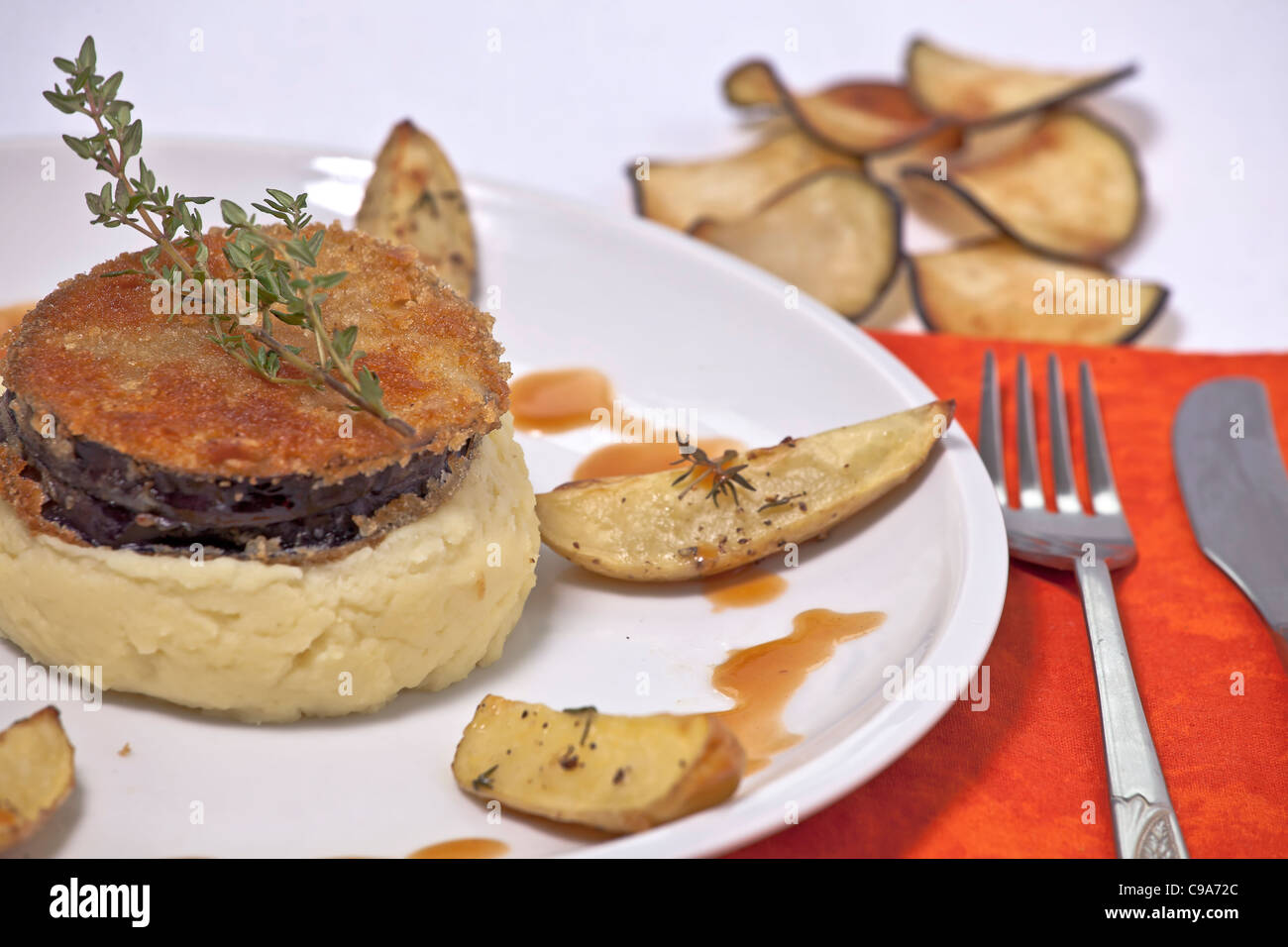 Eggplant Cordon Bleu stuffed with Swiss cheese and red pesto, served with mashed potatoes and thyme  Stock Photo