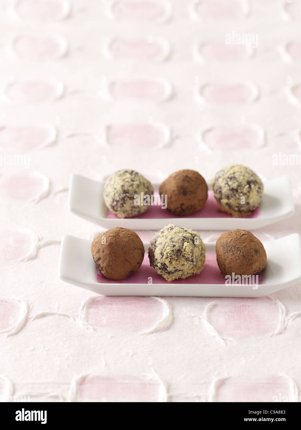 Chocolate truffles on white platters Stock Photo