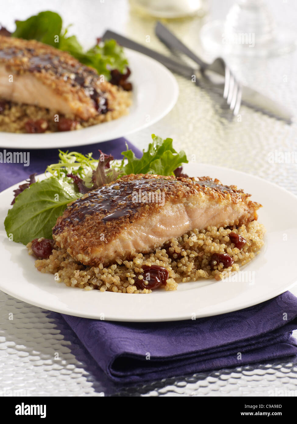 Cherry salmon fillet dinner over grains served with a leafy green salad Stock Photo