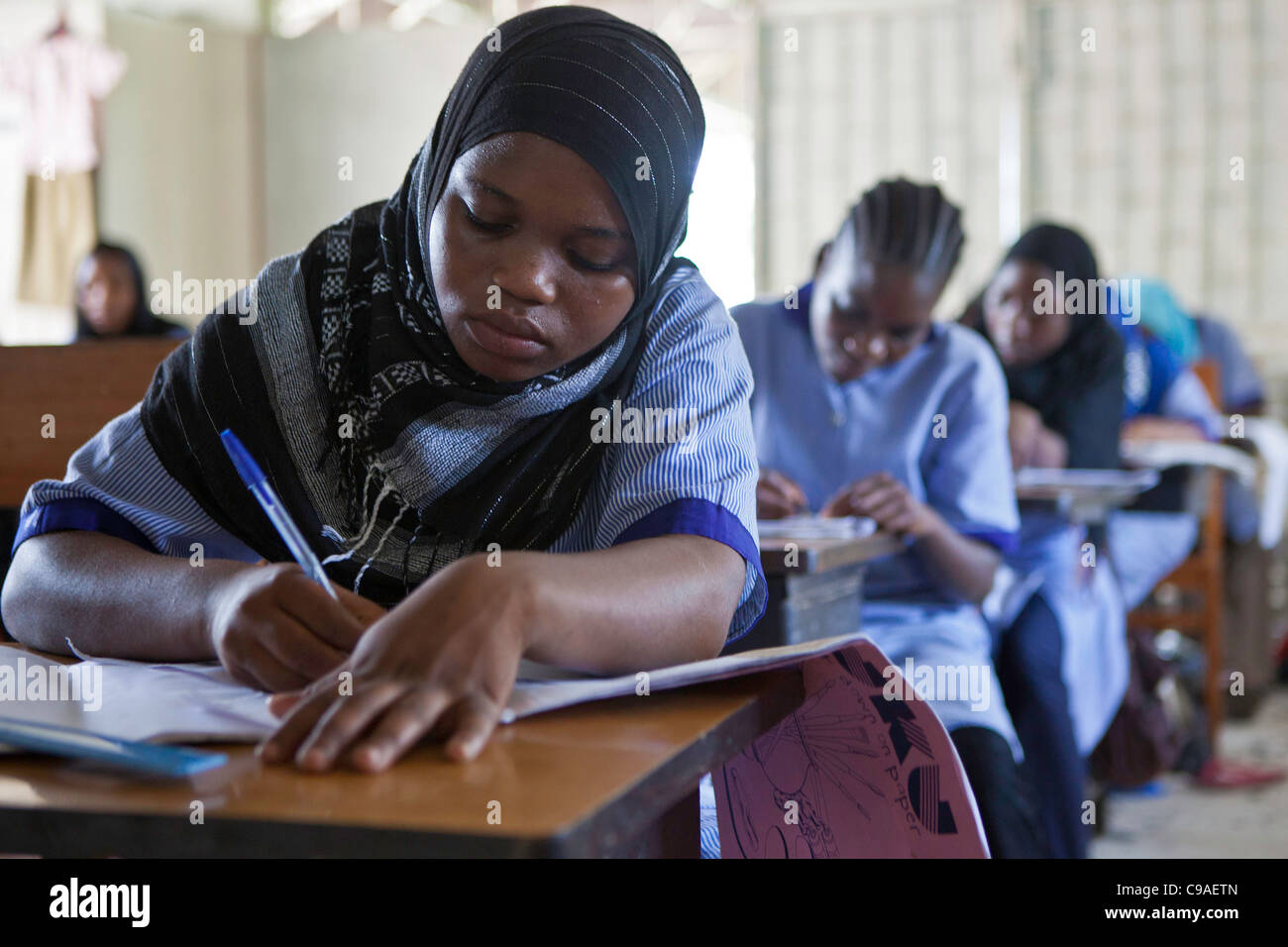 13 and 14 year olds study dress making during a lesson at the Wema Centre, Mombassa, Kenya. Stock Photo