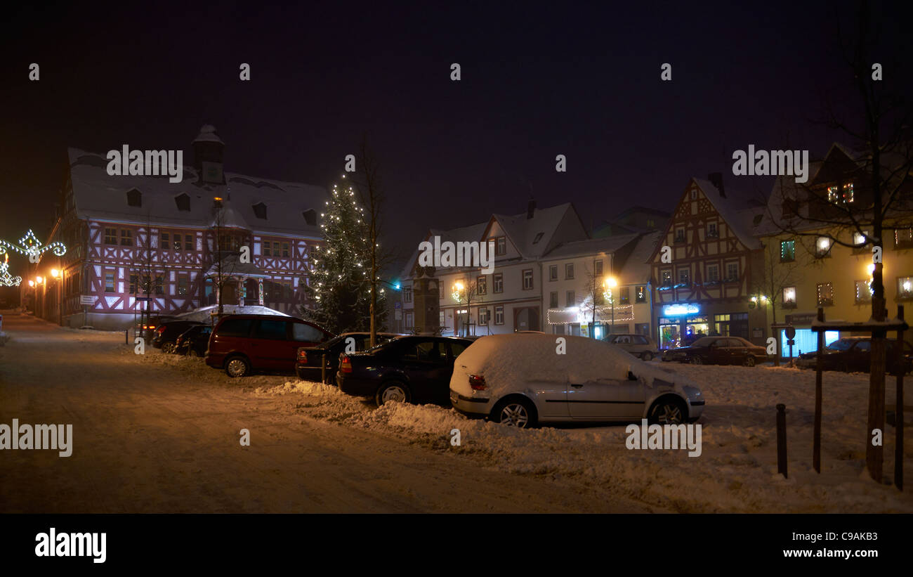 Snow covered centre square with historical town hall at night Stock Photo