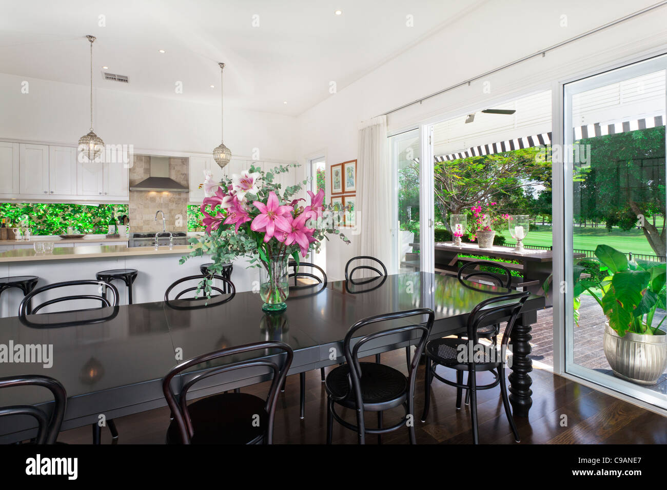 Stylish open plan kitchen with stainless steel appliances and dining ...