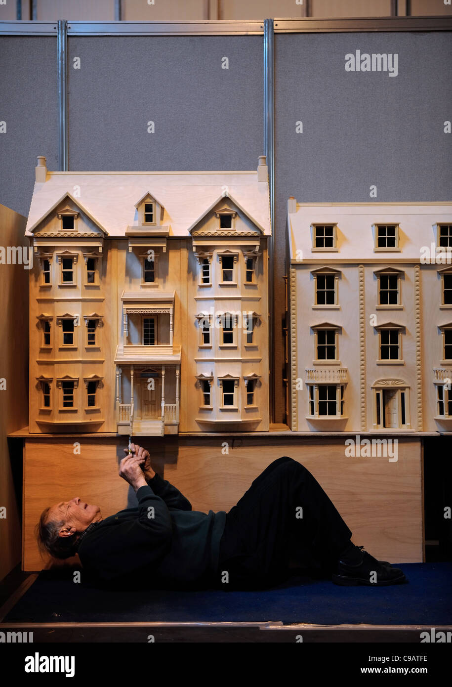 A miniatura enthusiast working on his Pennsylvanian style villa dolls' house at the miniature modelling Show at The NEC, Birming Stock Photo