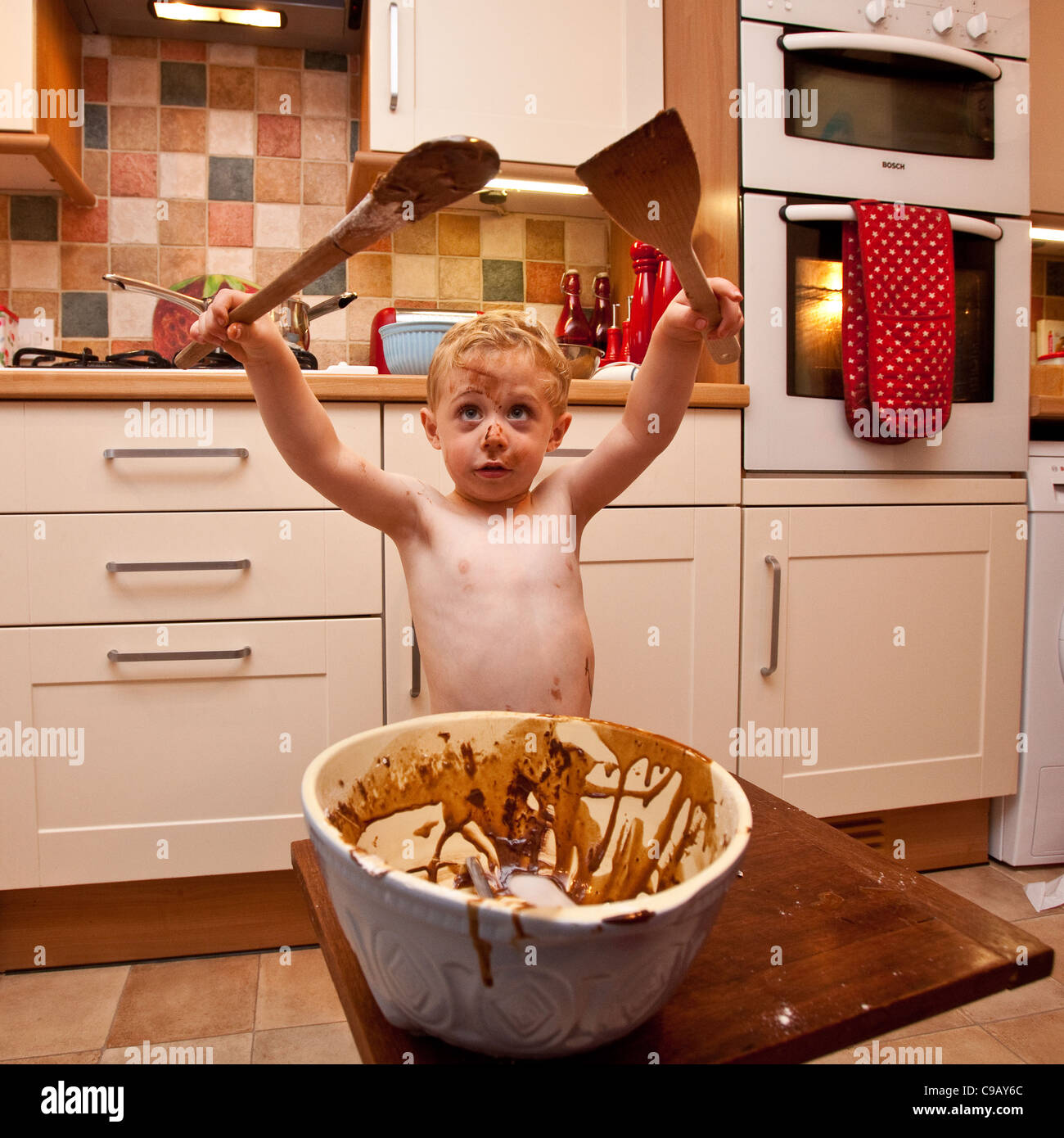 Young boy (2 1/2 Years old)  making chocolate cake, Hampshire, England. Stock Photo