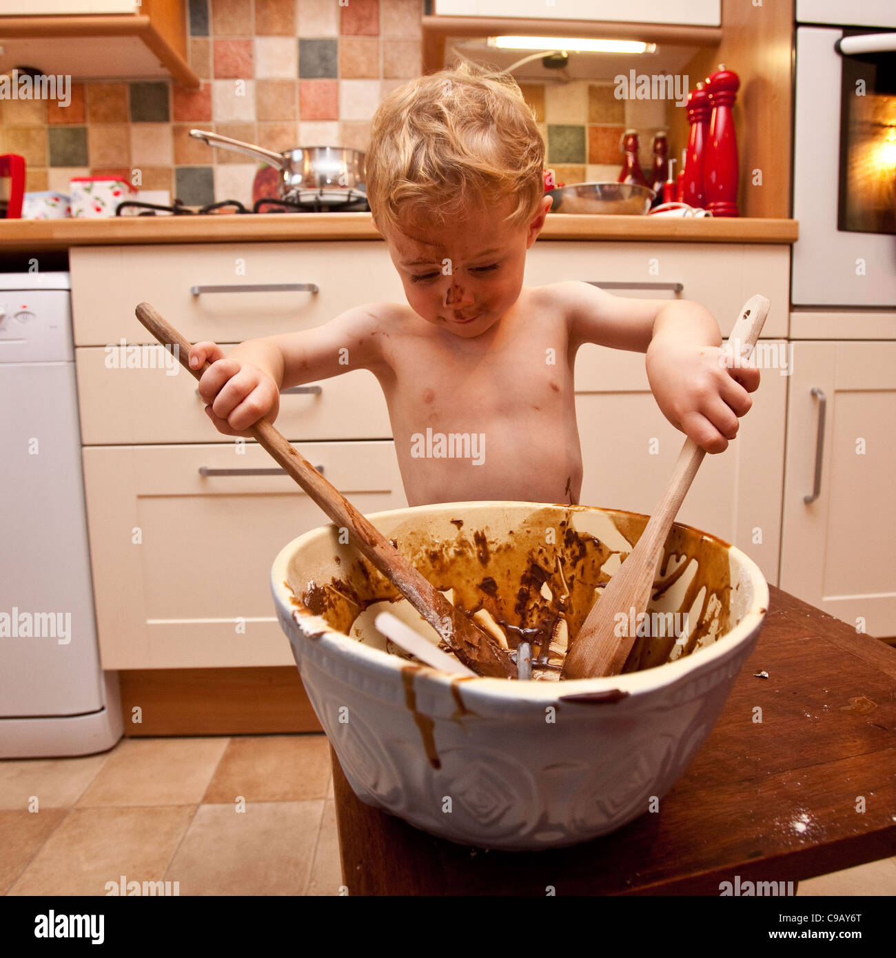 Young boy (2 1/2 Years old)  making chocolate cake, Hampshire, England. Stock Photo