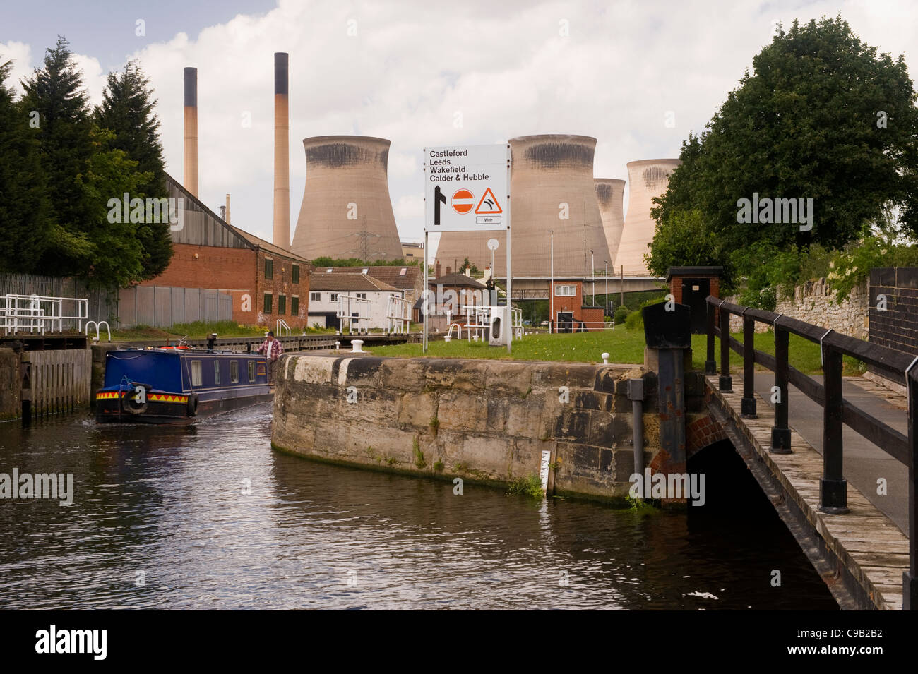 Cooling towers & chimneys of Ferrybridge 'C' Power Station & narrow boat sailing on Aire and Calder Navigation Canal - West Yorkshire, England, UK. Stock Photo