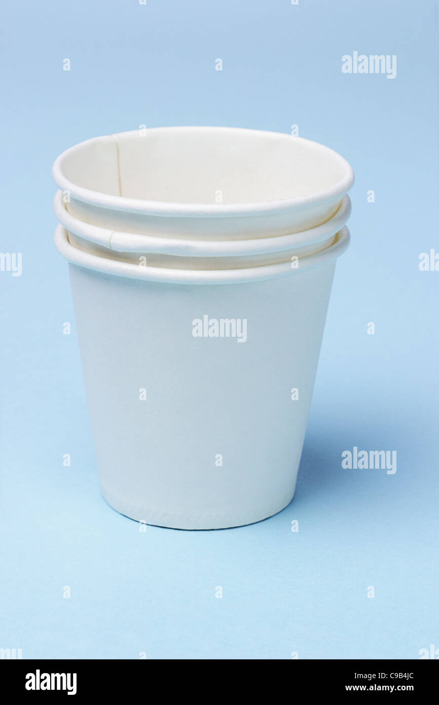 Stack of disposable paper cups on blue background Stock Photo