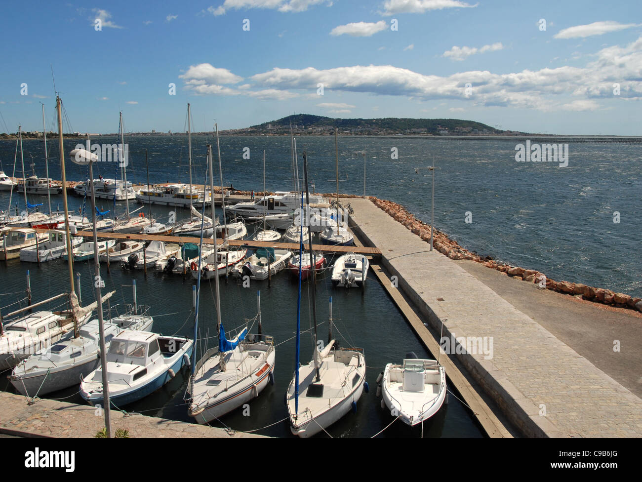 Sail boats moored at Bouzigues' marina of the Etang de Thau with Mount St-Clair of Sète at the distance, Languedoc-Roussillon Stock Photo