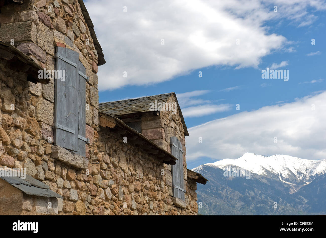 Gables of a natural stone building of Fort Liberia in Villefranche-de-Conflent with view of snow-capped Canigou mountain Stock Photo