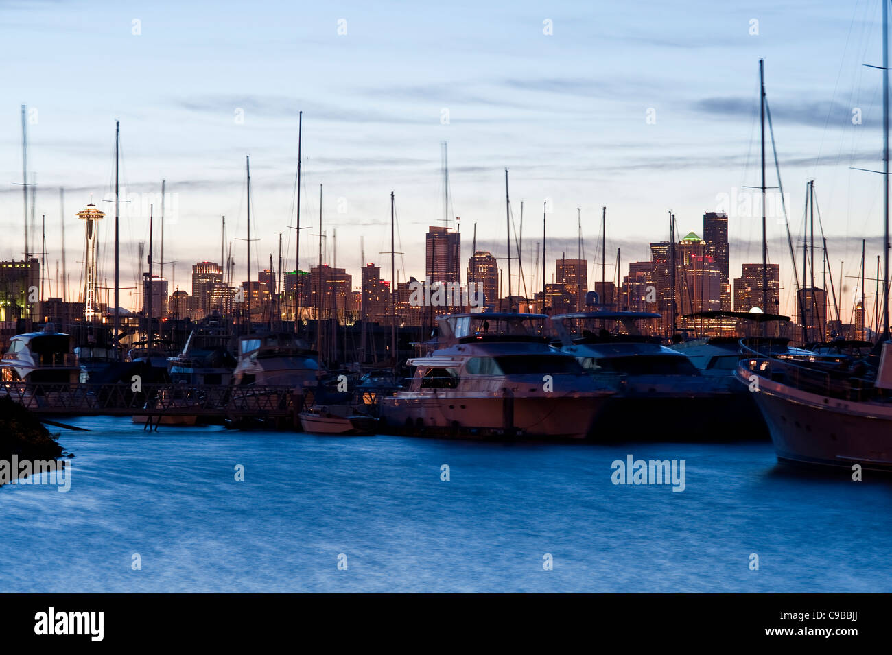 Elliott Bay Marina at sunrise with boats moored at docks and Seattle Skyline Washington State USA Stock Photo