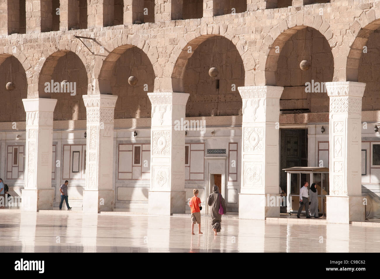 Visitors in the open-air courtyard of the Umayyad Mosque in the old city of Damascus, Syria. Stock Photo