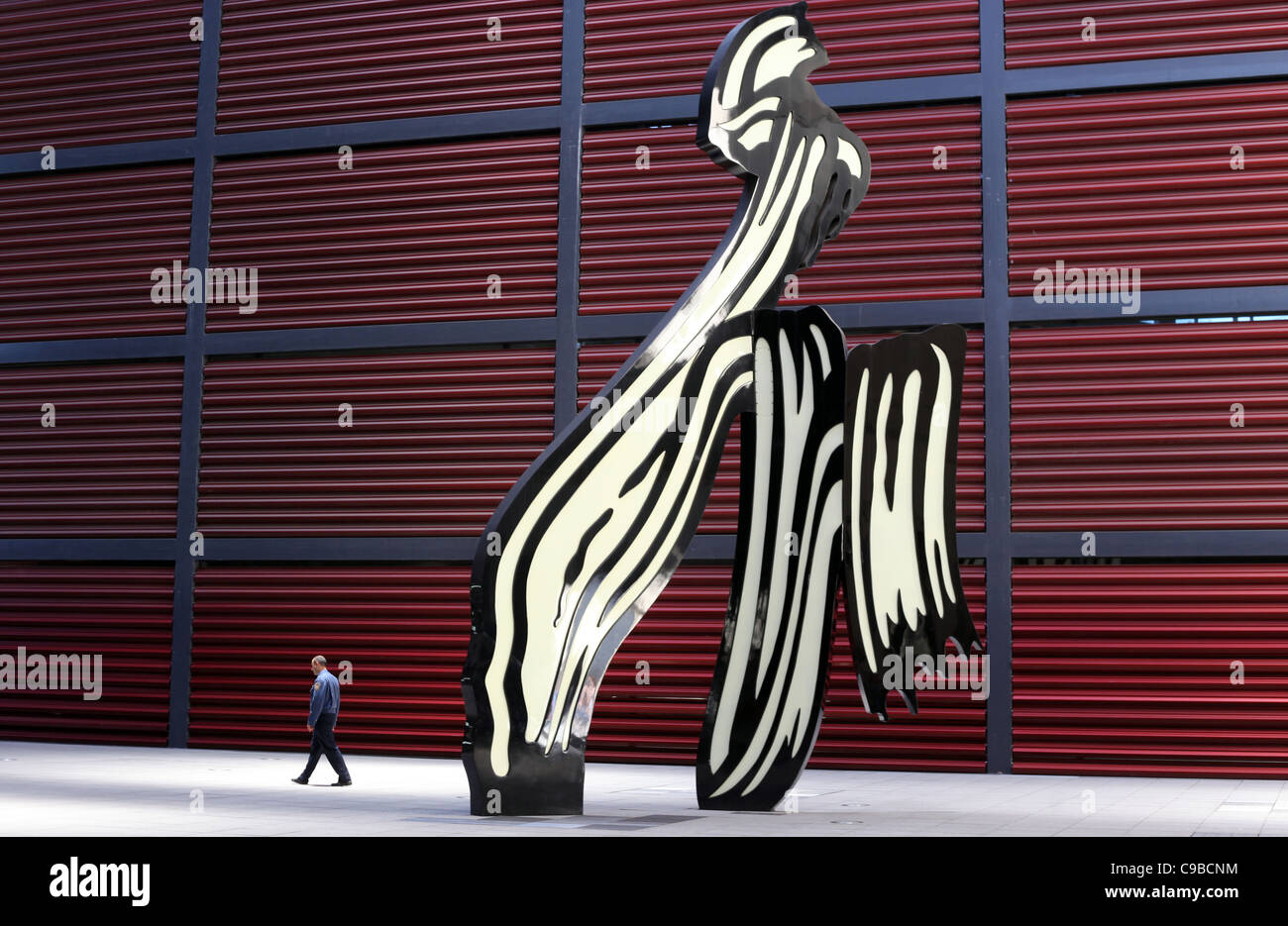 A visitor walks past a sculpture on display at the Museo Nacional Centro de Arte Reina Sofía gallery in Madrid, Spain. Stock Photo