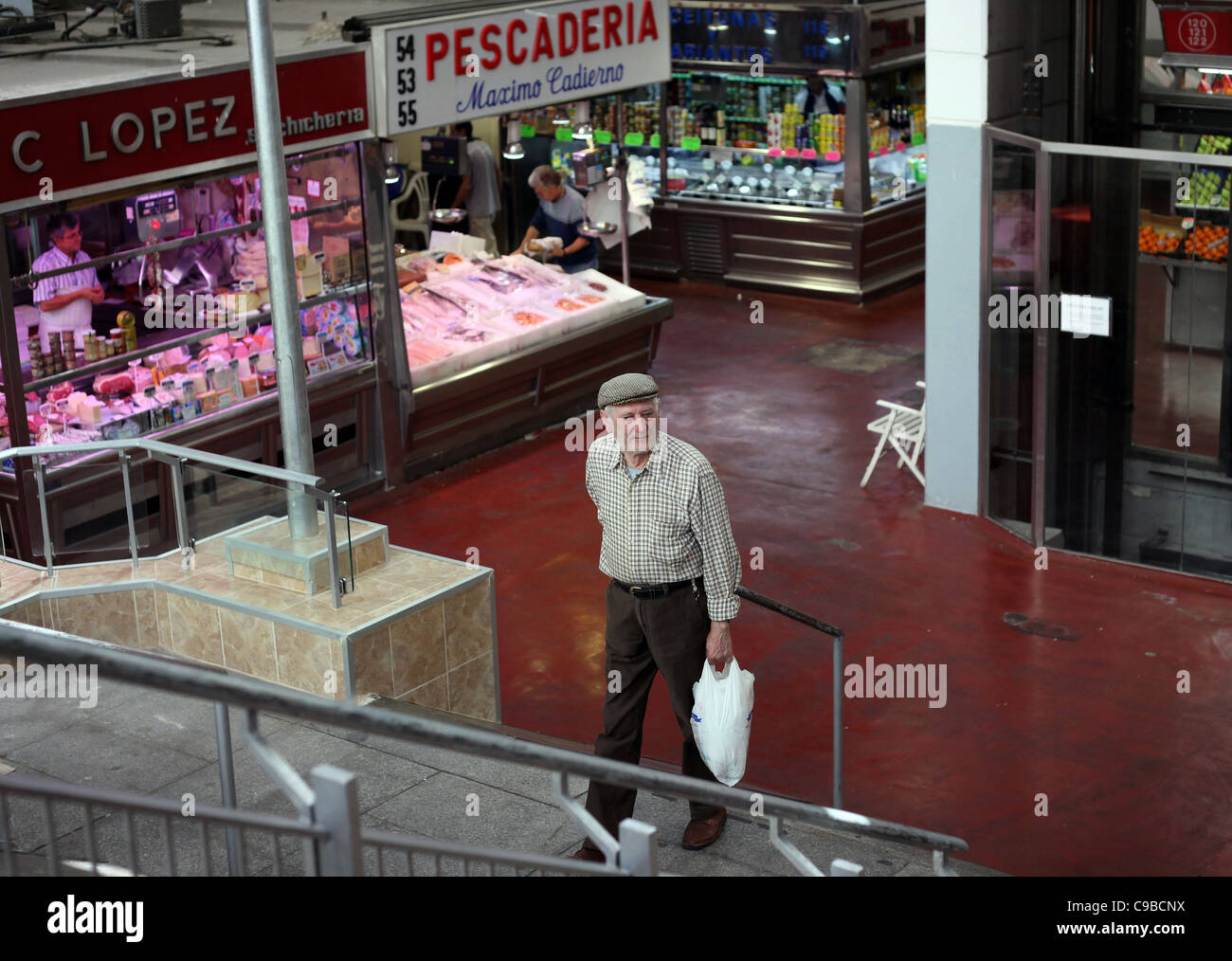 A local resident does grocery shopping in a indoor market in the latin quarter of Madrid. Stock Photo