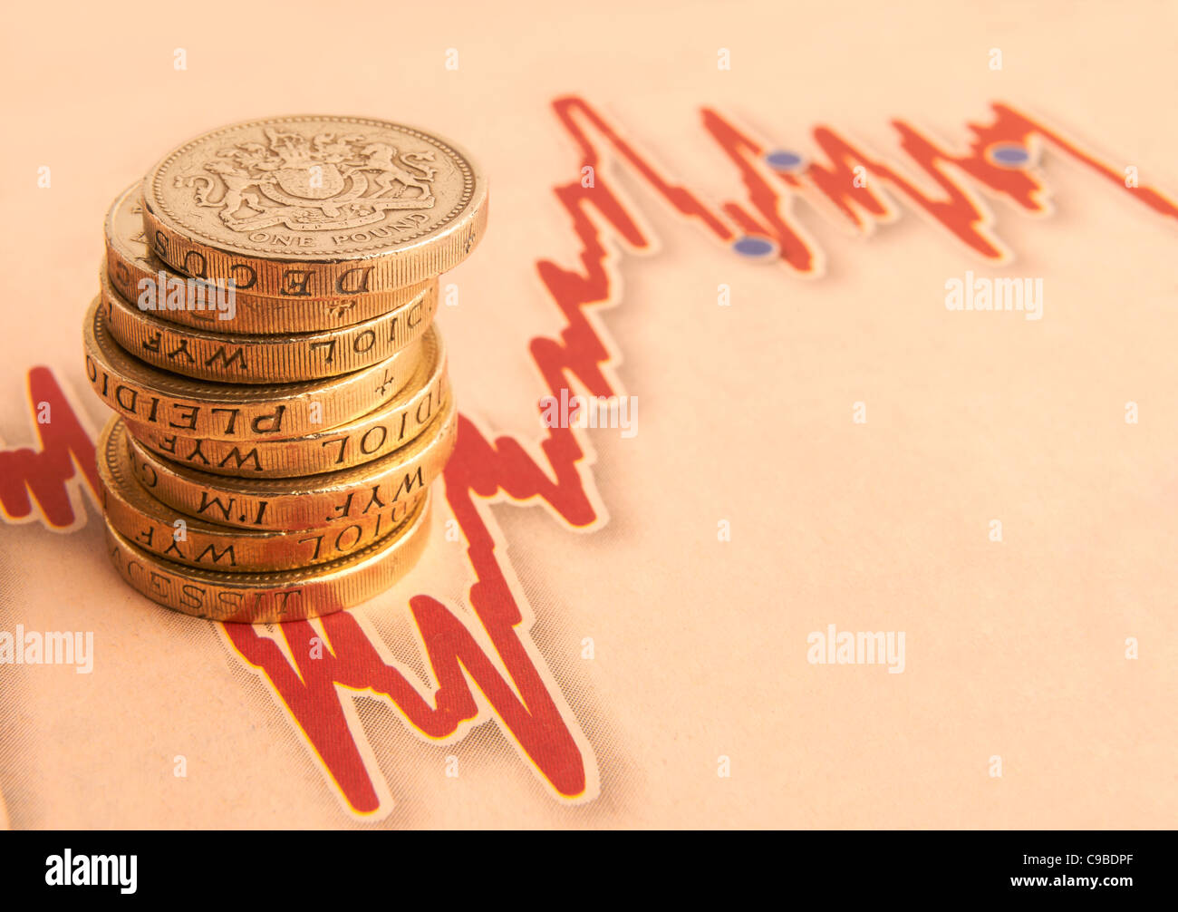 stack of one pound coins on fluctuating graph with space for copy Stock Photo
