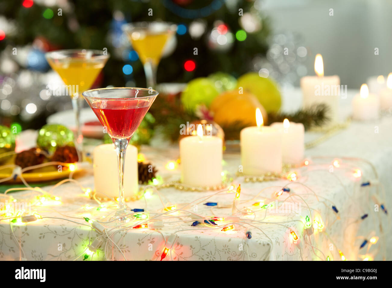Image of holiday objects cocktails, burning candles and Christmas