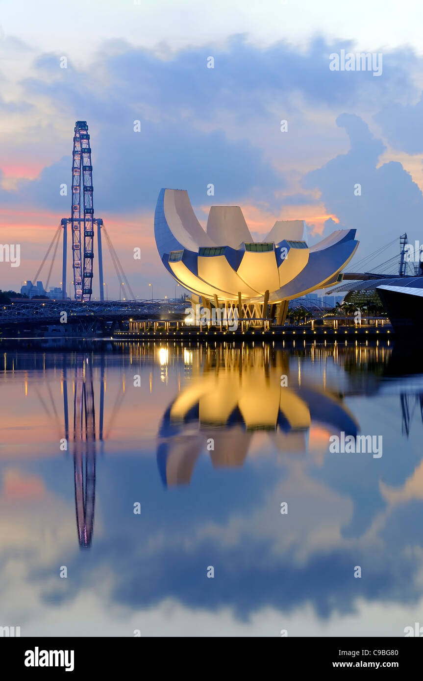 The Singapore ArtScience Museum overlooking the Singapore Flyer. This photo was taken at sunrise from the Merlion Park. Stock Photo