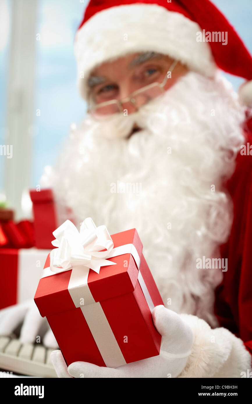 Photo of Santa Claus hand holding red giftbox Stock Photo - Alamy