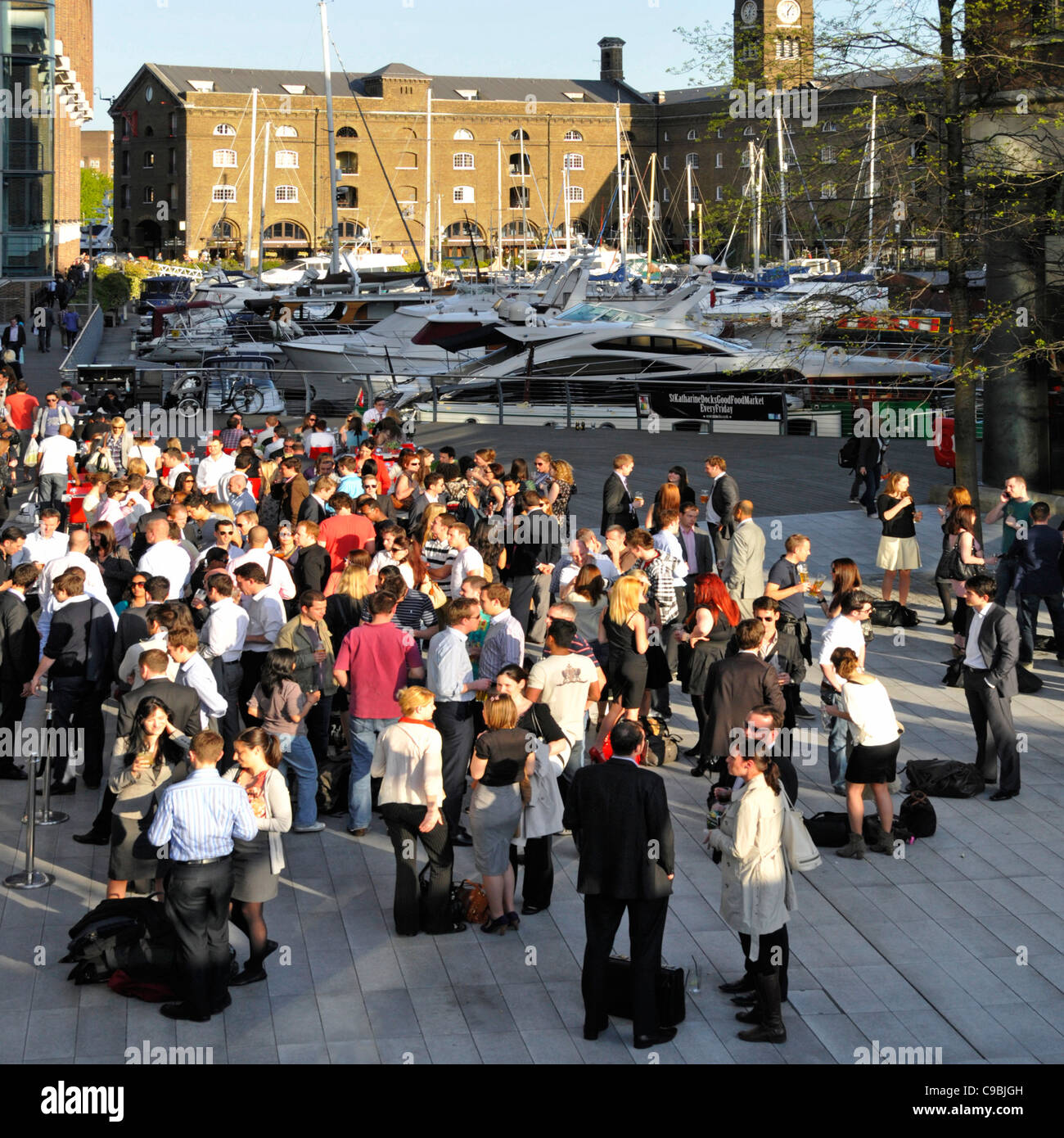 Crowd of office workers after work drinks group of people socialising outside bar & restaurants St Katharines Dock Tower Hamlets London England UK Stock Photo