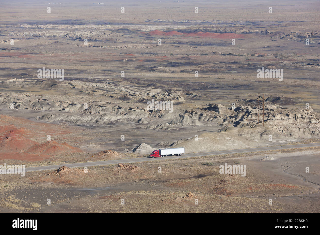 AERIAL VIEW. Moving truck in a desert landscape. Bisti De-Na-Zin Wilderness, San Juan County, New Mexico, USA. Stock Photo