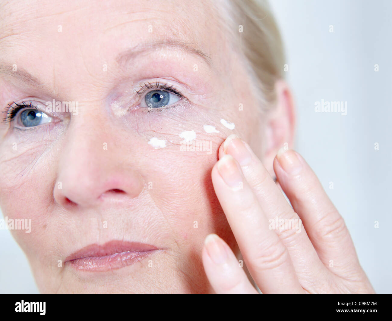 Senior woman applying face cream on face, close up Stock Photo - Alamy