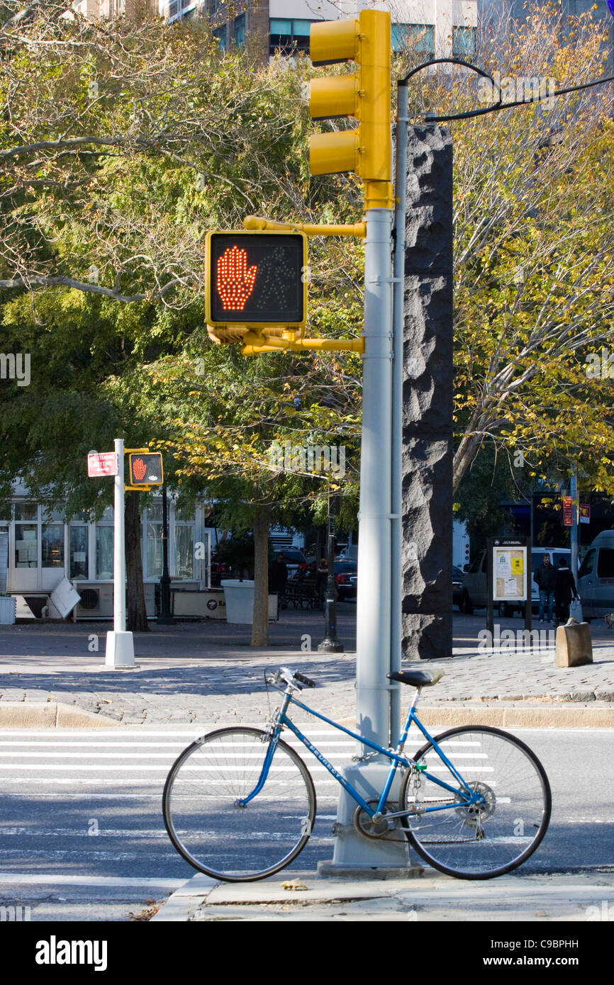 Bicycle Lent up against a Pedestrian crossing sign in New York City Stock Photo