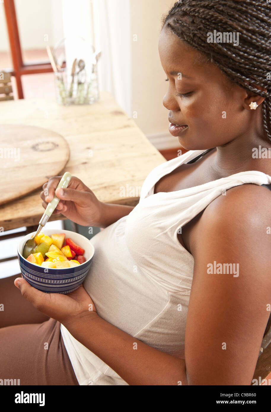 Pregnant woman eating fruit salad, Johannesburg, Gauteng Province, South Africa Stock Photo