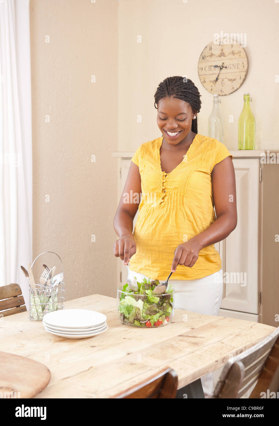 Pregnant woman tossing green salad, Johannesburg, Gauteng Province, South Africa Stock Photo