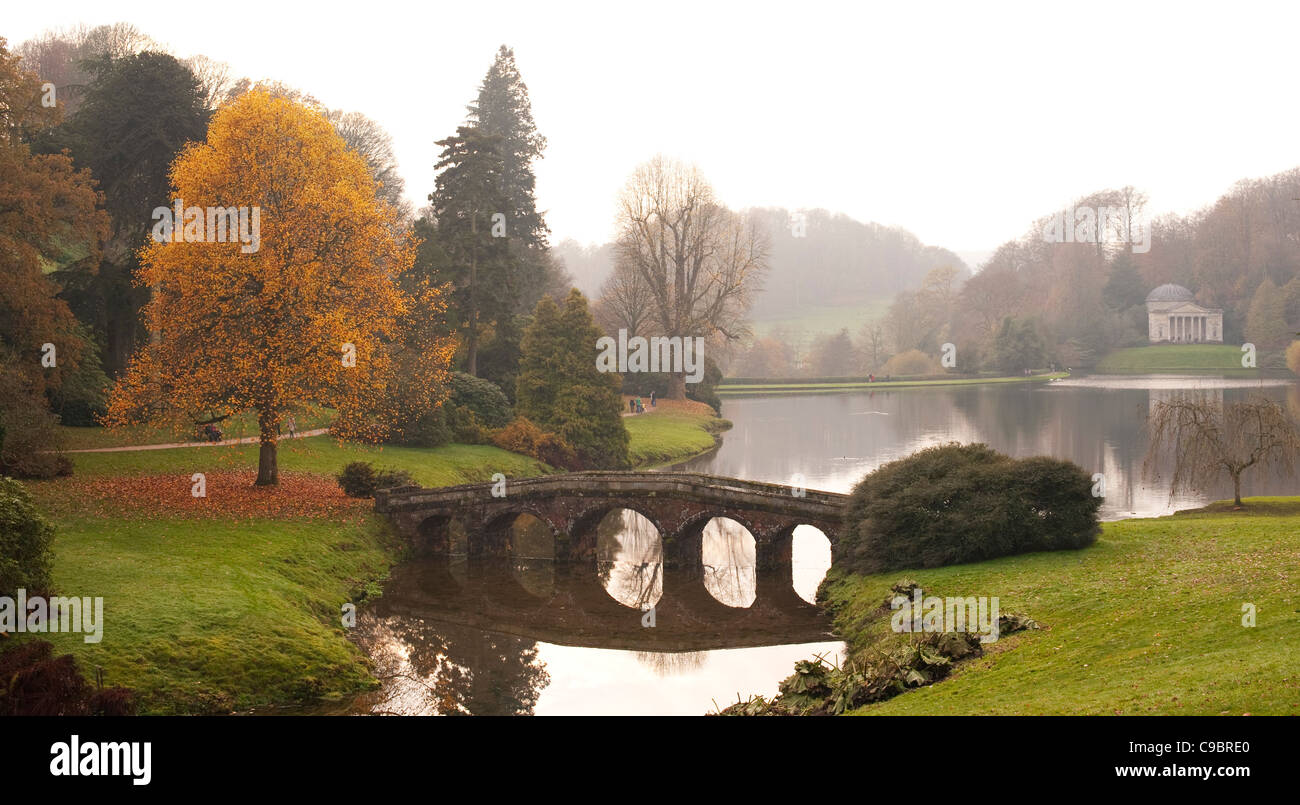 Palladian bridge with reflection of autumn trees in lake, England UK Stock Photo