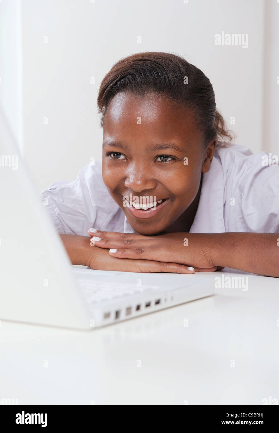 Teenage female student smiling whilst using laptop, Cape Town, Western Cape Province, South Africa Stock Photo
